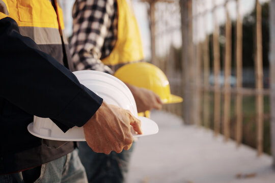 A team of engineers wearing hard hats inspect construction and inspect the site to ensure quality and compliance with design specifications, safety standards and project requirements.