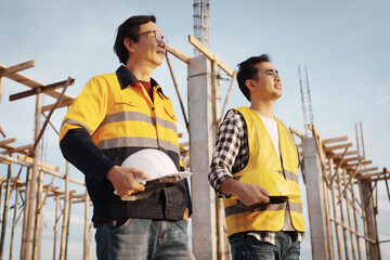 A team of engineers wearing hard hats inspect construction and inspect the site to ensure quality...