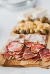 Charcuterie board with assorted meats and cheeses on wooden platter
