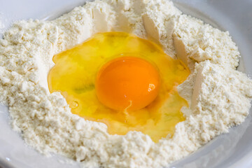 Mixing flour and egg in preparation for baking dough
