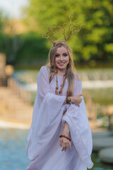 Beautiful girl with long hair and horns in a white dress