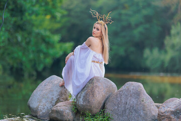 Beautiful girl with long hair and horns in a white dress