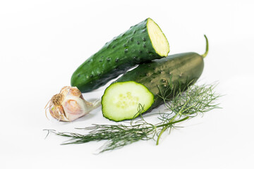 Fresh cucumbers and garlic with dill on a white background
