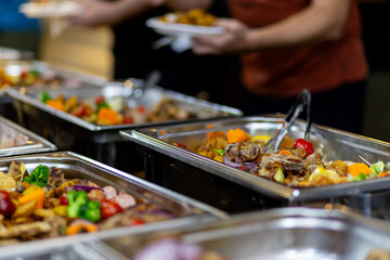 Buffet spread featuring a variety of dishes at a gathering event in the evening