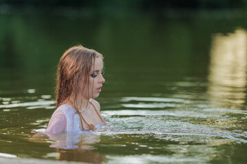 Fototapeta premium Beautiful Girl with long hair swims and dances in water