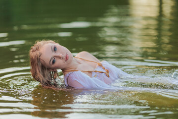 Fototapeta premium Beautiful Girl with long hair swims and dances in water