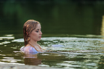 Fototapeta premium Beautiful Girl with long hair swims and dances in water
