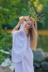 Beautiful girl with long hair and horns in a white dress