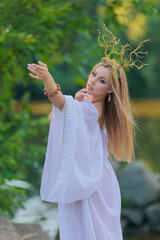 Beautiful girl with long hair and horns in a white dress