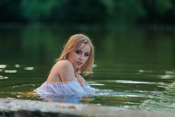 Fototapeta premium Beautiful Girl with long hair swims and dances in water