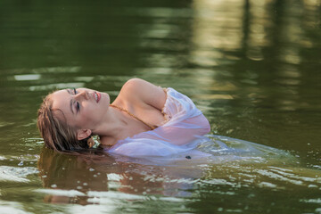 Beautiful Girl with long hair swims and dances in water