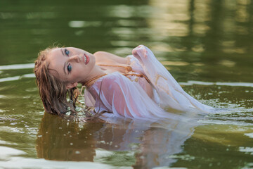 Beautiful Girl with long hair swims and dances in water
