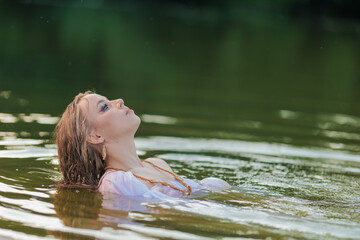 Beautiful Girl with long hair swims and dances in water
