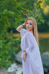 Beautiful girl with long hair and horns in a white dress