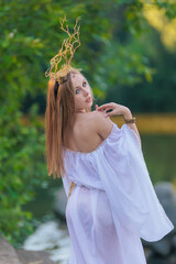 Beautiful girl with long hair and horns in a white dress