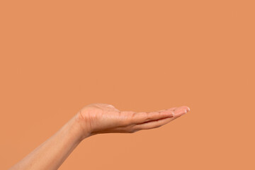 Open hand gesture against a warm orange background inviting offers and sharing with a calm and...