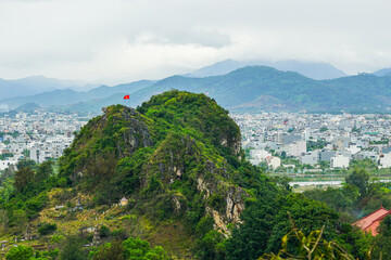 One of the Marble Mountains of Da Nang, the red flag of Vietnam on the top of the mountain