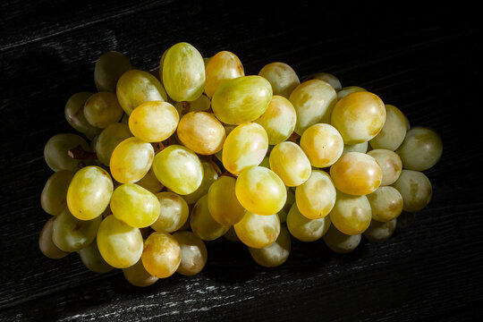 white grape on black wood background