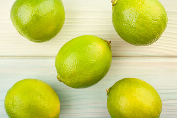 limes on wood background top view