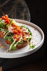 Open Chicken Sandwich with Avocado & Chickpeas – Toasted bread topped with grilled chicken breast, fresh arugula, avocado slices, roasted chickpeas, tomato salsa, and creamy dressing.