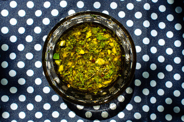 Chimichurri sauce in a glass bowl on a polka dot table 