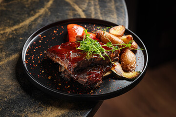 BBQ Ribs with Roasted Vegetables – Juicy barbecue-glazed pork ribs served with crispy roasted baby potatoes, grilled zucchini, and red pepper.