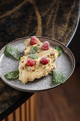 Ricotta Cheesecake with Raspberries & Pistachio.
Light ricotta-based cheesecake slice, topped with fresh raspberries, crushed pistachios, powdered sugar, and mint leaves.
