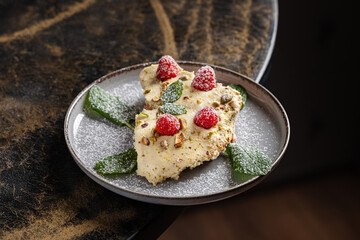 Ricotta Cheesecake with Raspberries & Pistachio.
Light ricotta-based cheesecake slice, topped with fresh raspberries, crushed pistachios, powdered sugar, and mint leaves.