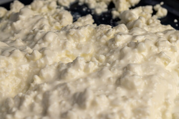 cottage cheese with sour cream, sprinkled with liquid sour cream, lumps of freshly made fermented milk product