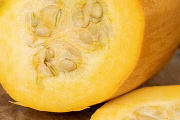 Slice orange pumpkin or zucchini, slicing ripe zucchini on a black cooking table, close up
