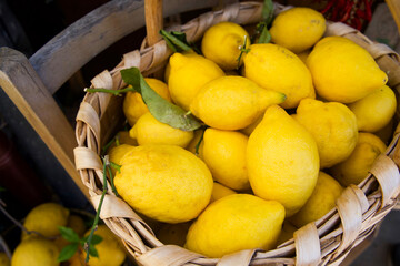 Freshly harvested lemons piled in a woven basket, showcasing vibrant yellow color and natural texture, surrounded by rustic wooden elements, emphasizing organic produce and farm-to-table freshness