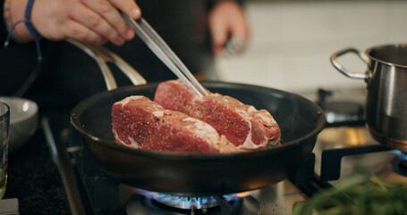 Cooking, stove and chef with meat in pan in kitchen for culinary skill, recipe and meal prep for...