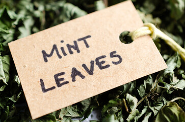 Dried mint leaves with a label in recycled paper written in English. 