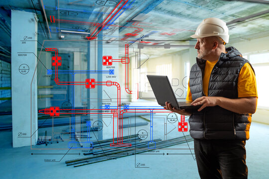 Engineer with laptop analyzing HVAC system blueprint at construction site, focusing on digital planning and building services. – Engineering, Construction, HVAC, Building Design.