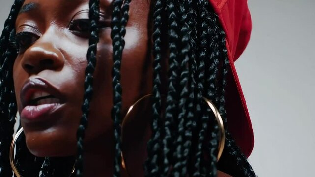 Close-up profile of a passionate female rapper delivering powerful lyrics, highlighting her expressive face and braided hairstyle