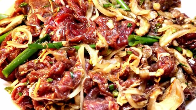 Close-up of marinated beef strips with sliced vegetables