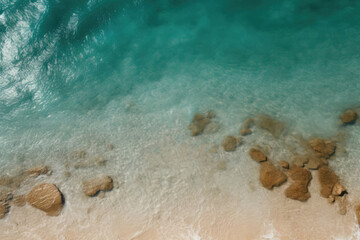 Beautiful beach with clear turquoise water, sandy shore, and rocks at water&rsquo;s edge.