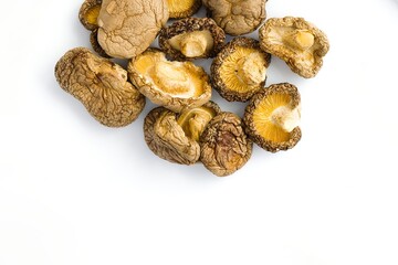 Rustic dried shiitake mushrooms set on a white background, revealing their unique texture and natural flavor.
