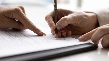 Confirming deal. Close up female lawyer consultant realtor hand show client place to sign on paper...