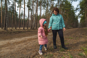 Grandmother and granddaughter walking in the forest