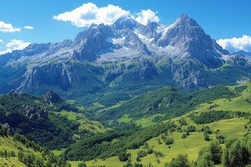 Obraz premium Majestic mountain range rises above a lush green valley landscape