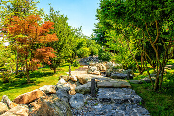 Decorative alley with stone rubble and a stream in a public park in the city of Krasnodar