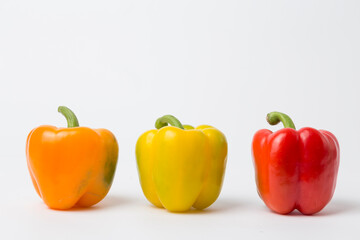 Yellow, Red, and Orange Bell Peppers on White Background