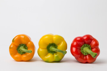 Yellow, Red, and Orange Bell Peppers on White Background