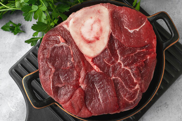 Meat. Ossobuco veal steak with herbs and spices. On a light colored background. Top view. Close-up
