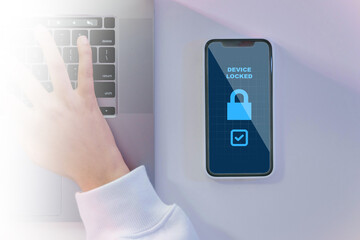 Smartphone with Device Locked on Screen Near Laptop