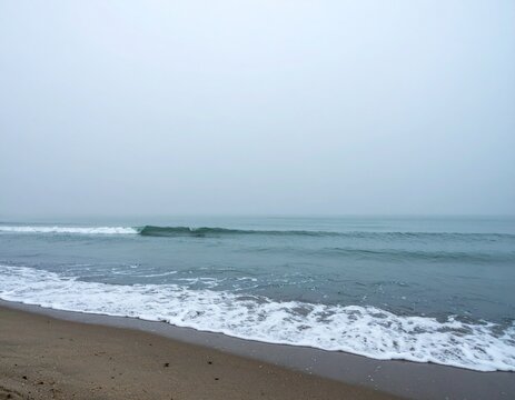 Moody Foggy Beach with Blurred Sea Textures and Mysterious Stillness for Morning Mist Coastal Background