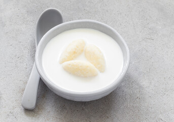 Children food. Milk soup with cottage cheese quenelles. Close up	