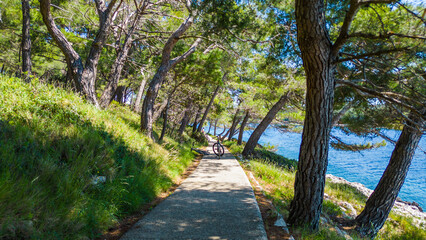 Aerial view of Camping Čikat on Lo&scaron;inj (Losinj) island, surrounded by a beautiful pine forest and the Adriatic Sea. Known for XTERRA races, biking trails, and crystal-clear coastline views