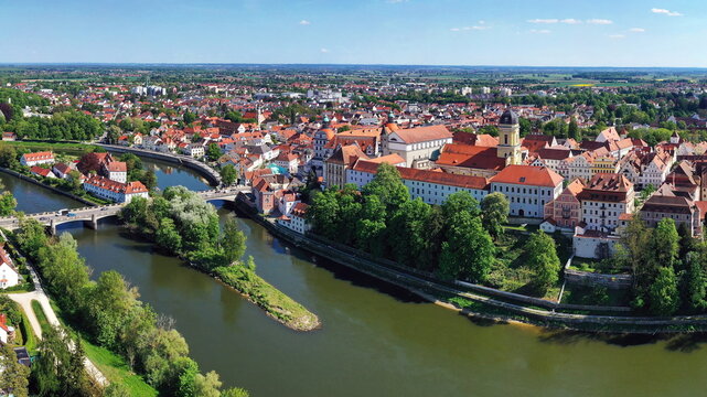 Eine beeindruckende Luftaufnahme von Neuburg an der Donau, einer malerischen Stadt in Bayern, Deutschland. Die Donau schl&auml;ngelt sich durch die Stadt und bildet eine kleine Insel.